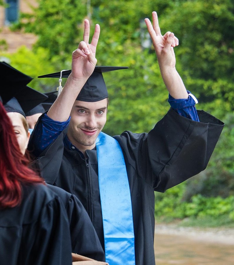 A graduate flashes the "victory" sign.