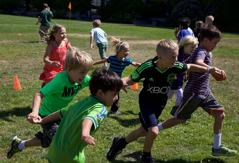 Children participating in Western Kids Camp run a relay race on south campus on Thursday, July 23. Photo by Alex Bartick / WWU Communications and Marketing intern