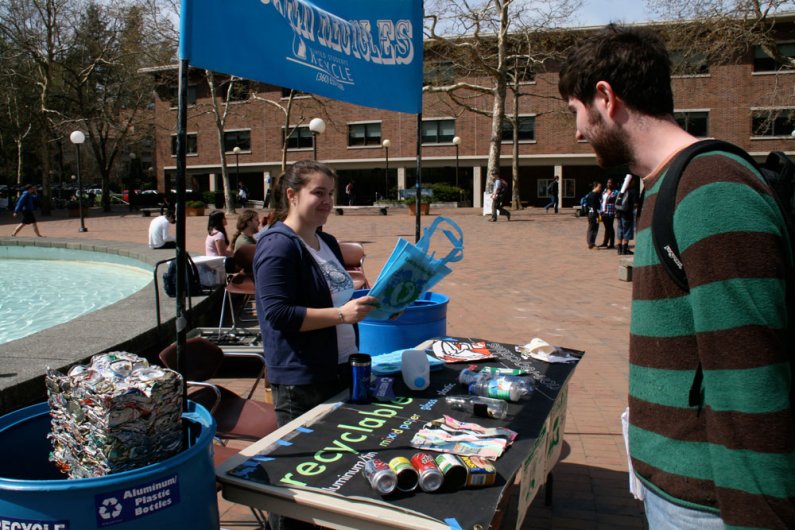 AS Recycle Center educator Rachel King hands out "recycle" bumper stickers and reusable grocery bags in red square Friday, April 16. "We're trying to promote recycling awareness and help students understand what is good to recycle and what isn't," King sa