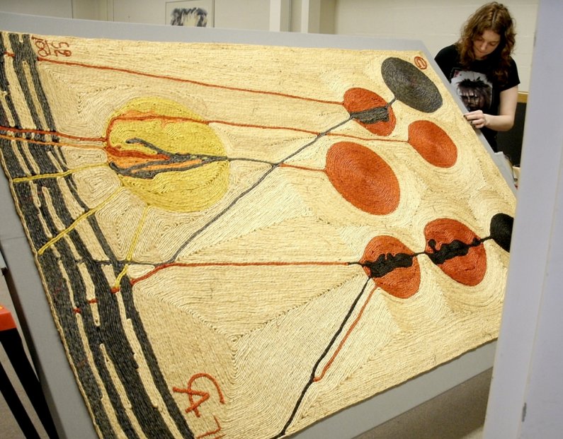 An art restorer works on a rare collection of tapestries from Alexander Calder in advance of their display at Western Washington University in one of three new galleries in the Performing Arts Center. Courtesy photo