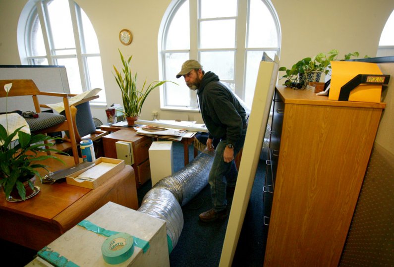 <p>
	Craig Evans, a maintenance mechanic with Western Washington University Facilities Management, configures a duct to blow moisture from the inside of the offices of the president and provost on the fourth floor of Old Main. Photo by Matthew Anderson |