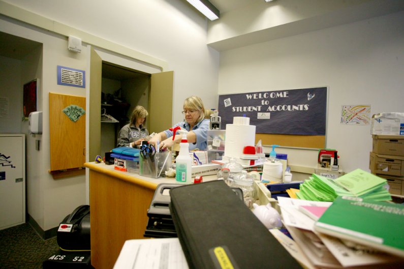 <p>
	In the offices of Student Financial Services on the third floor of Old Main, Mary Nichols salvages office supplies from water-damaged areas while student Samantha Gunderson and staff member Rian Barnes remove damaged papers from a storage closet. Ph