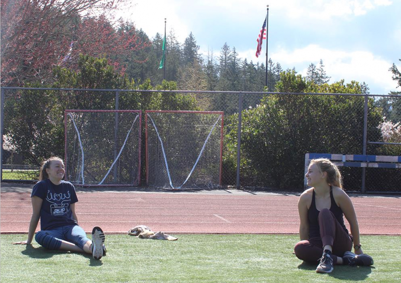 Brianne McCaslin, a Communication Sciences and Disorders major from Seattle (left) and Anna Wohnoutka, an American Cultural Studies major from Seattle, take a break from online classes to enjoy the sun outside Wade King Recreation Center.