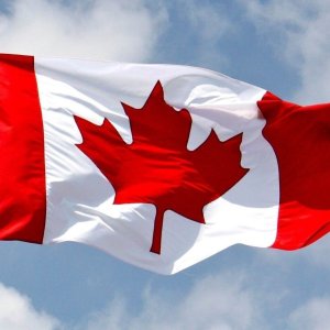 A Canadian flag waves in a stiff breeze