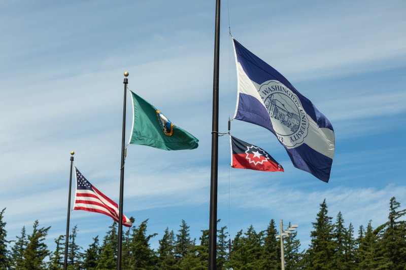 The Juneteenth flag flies below Western's flag, with the Washington state and American flags in the background at Western's Flag Pavilion on a sunny day.