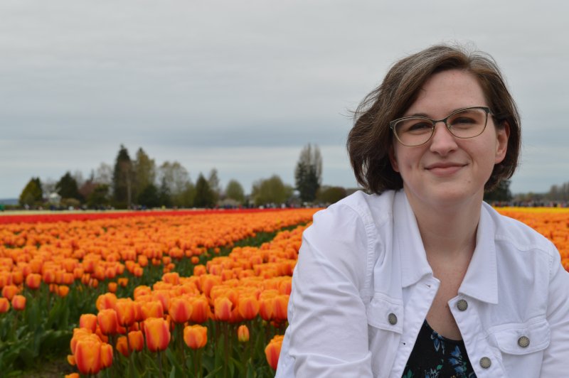 Caitlin Bannister, with a field of orange flowers in the background