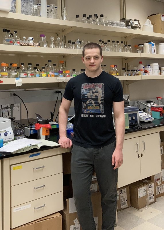 Heino Hulsey-Vincent stands in a lab with beakers in the background