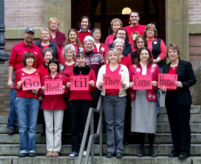 Staff members from Western Washington University pose on the steps of Old Main. They have been wearing red on Fridays to show their support for troops in the U.S. military. Back row, left to right: Nancy Anderson, Alex Allyne, Vi Thorpe, Kayle Walls (stud