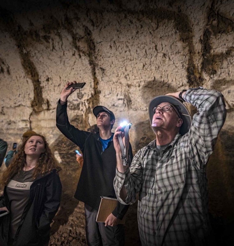 Scott and students look at mineral deposits deep in a lava tube underneath Santa Cruz Island in the Galapagos.