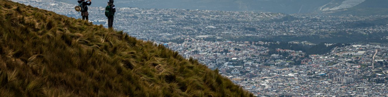 Two students look out over Quito, Ecuador, from a hillside.