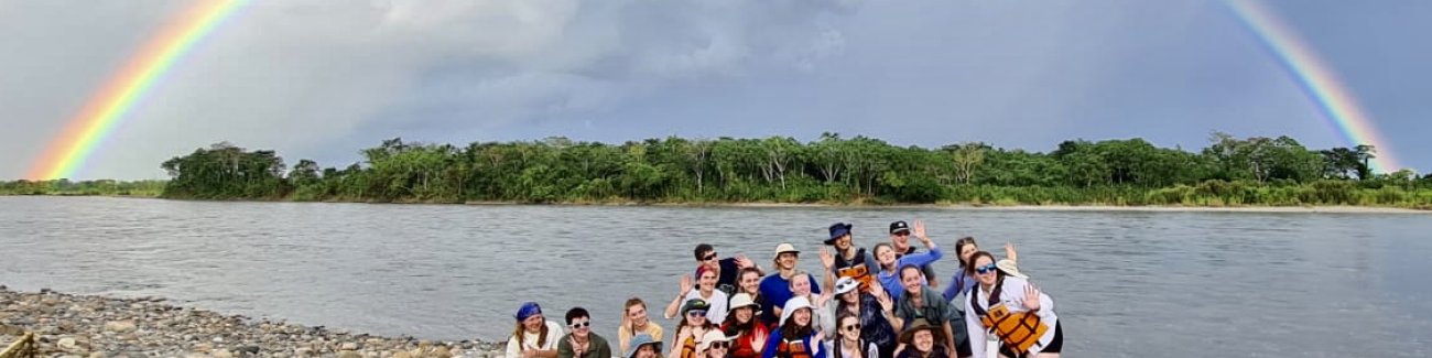 Students pose for a picture on the shores of Rio Napo, one of Ecuador‘s largest tributaries of the Amazon, beneath a rainbow that arches over the jungle on the other shore.