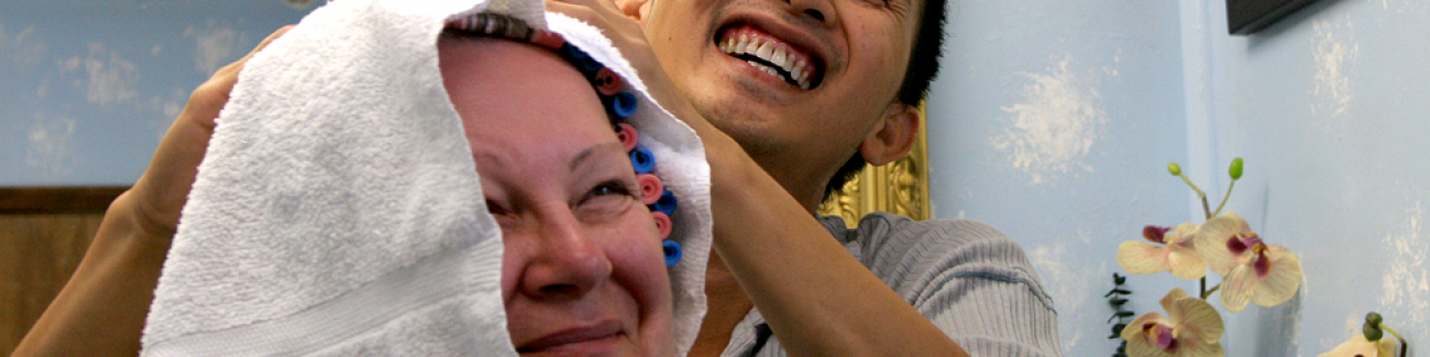 Thomas Tran, a custodian at Western Washington University and the owner of his own hair salon, laughs while styling the hair of Bellingham resident Gerri Green at his home studio. Tran, who has worked at Western for more than 10 years, also is an accompli