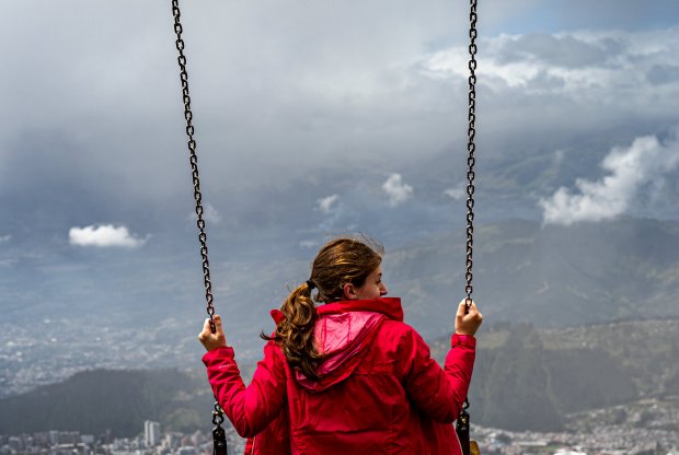 A student sits on the Swing in the Clouds, looking over Quito, Ecuador.