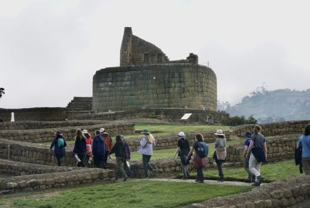 Students walk among the ancient stone walls of Ingapirca toward the Temple of the Sun.