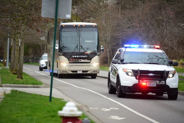The team bus is escorted onto campus by a University Police squad car with lights flashing