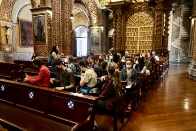 Students sit in the pews of the Church of la Compañía de Jesús, one of the most notable baroque cathedrals in South America 