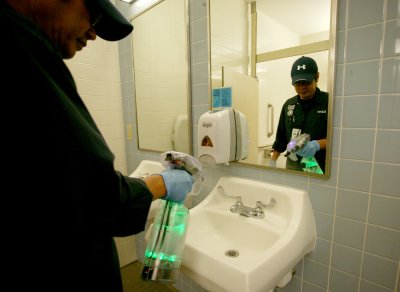 Roberto Lim, a custodian with WWU's Academic Custodial Services, cleans a bathroom sink in the Academic Instructional Center with ionized water. The water contains no chemical additives or cleaning products but sanitizes as well as green cleaning products