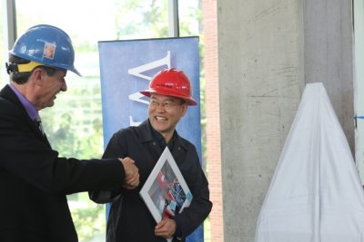 Western President Bruce Shepard congratulates artist Do Ho Suh on the dedication of Suh's sculpture, "Cause & Effect," on June 8 at the AIC West.
