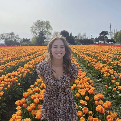 Allie Howard stands in a field of orange tulips