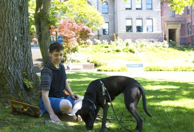 Freshman Ciaran Connolly and dog Delta enjoy some time in the sun on the Old Main lawn while waiting for a friend to get out of class