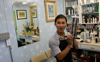 Thomas Tran proudly displays the first-ever trophy he won in a hairstyling competition, back in 1998. Photo by Matthew Anderson | WWU