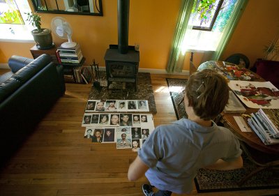 Katy Frank looks for inspiration at an array of model portraits in her Bellingham home. Frank uses the faces as starting points for her collages. Photo by Matthew Anderson | WWU
