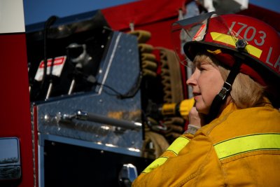 Janice Lapsansky puts on her fire captain's hat at the Sandy Point Fire Station on Friday, May 14. Photo by David Gonzales | University Communications intern