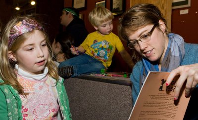 Sarah Weeks, a senior geology major at Western Washington University, reads to 7-year-old Jullian Cooper while her brother, 2-year-old Elliot, plays with crayons in the background at the 2010 MLK Day read-in at Village Books in Bellingham. File photo by J