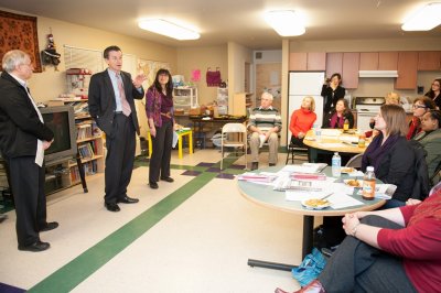 WWU President Bruce Shepard and Washington State Speaker of the House Frank Chopp (D-Seattle) speak along with LIHI Executive Director Sharon Lee to a group of volunteers, students and residents, Monday at a LIHI apartment building near Seattle. Photo by 