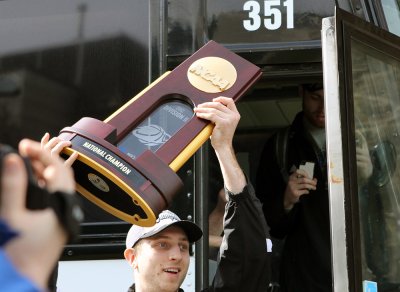 Western's Zack Henifin carries the team's national title trophy off the bus upon arriving on campus Sunday, March 25, 2012. A large group of fans welcomed the team home from Kentucky. Photo courtesy of Lillian Furlong