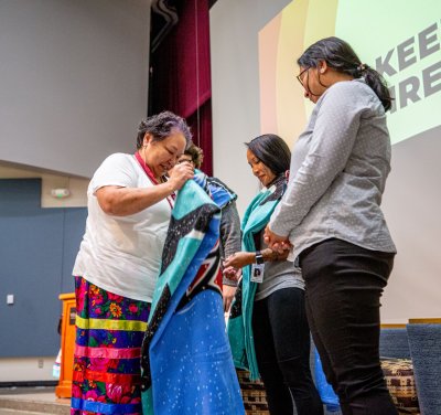 Western's Laural Ballew presents blankets on the stage for Indigenous Peoples' Day.